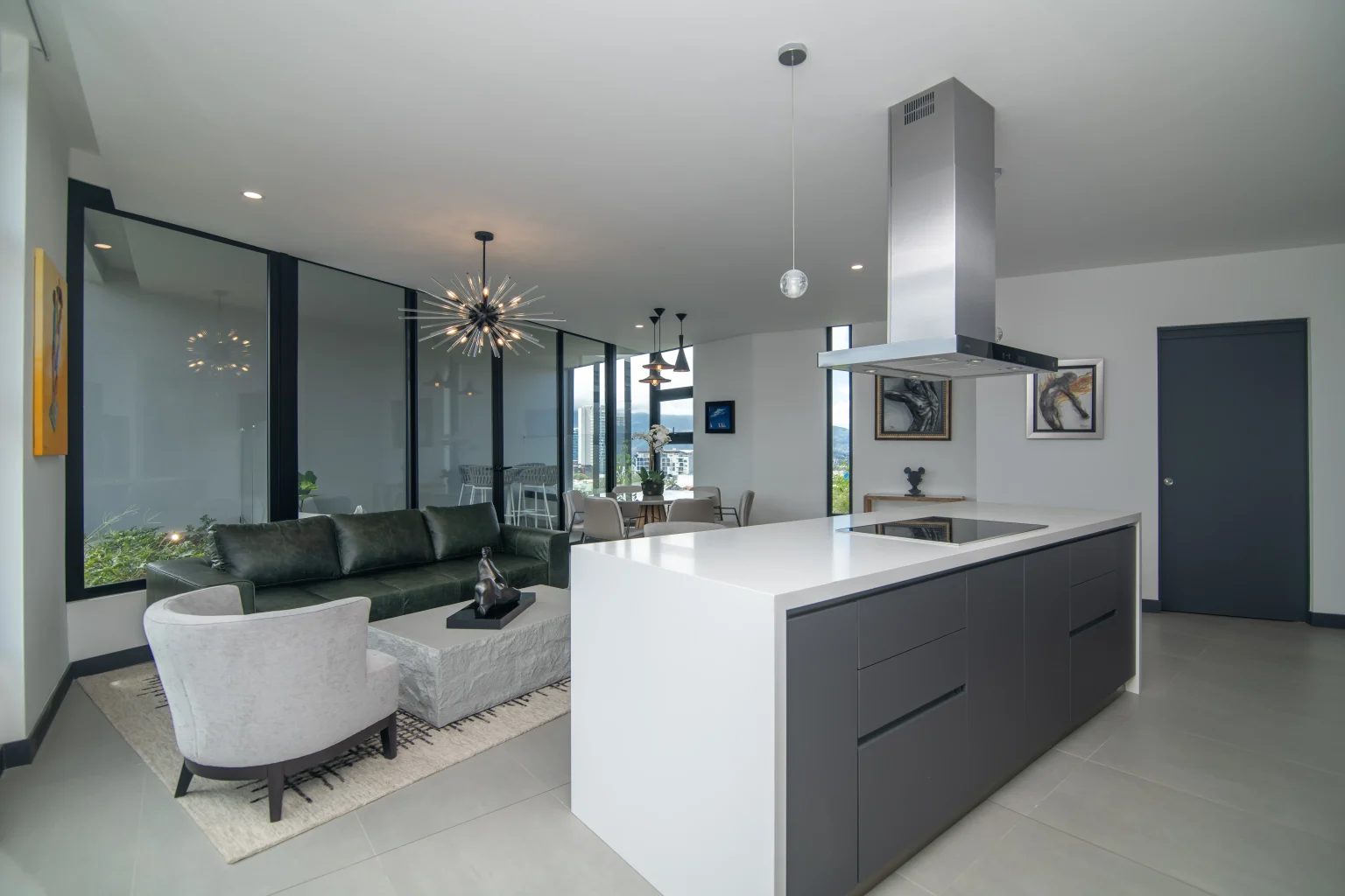 Social area with a green leather sofa and a sputnik chandelier