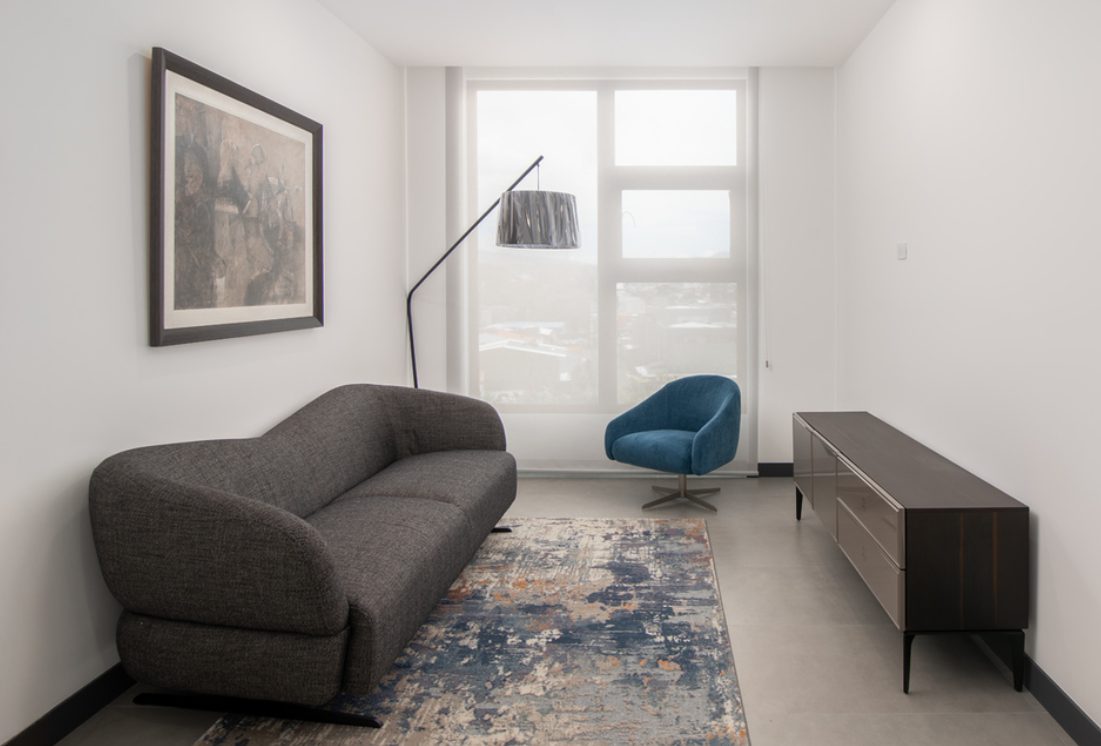 TV room with a gray sofa and blue accent chair