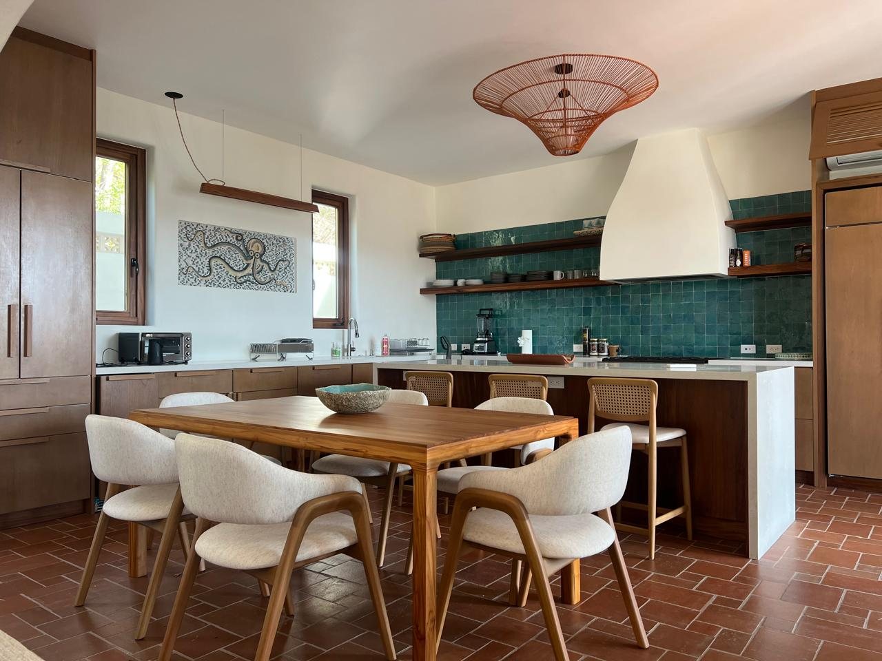 Dining table with cream chairs and a rattan pendant lamp