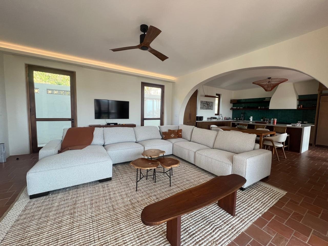 Living room with a light sectional sofa and an arched opening to the kitchen