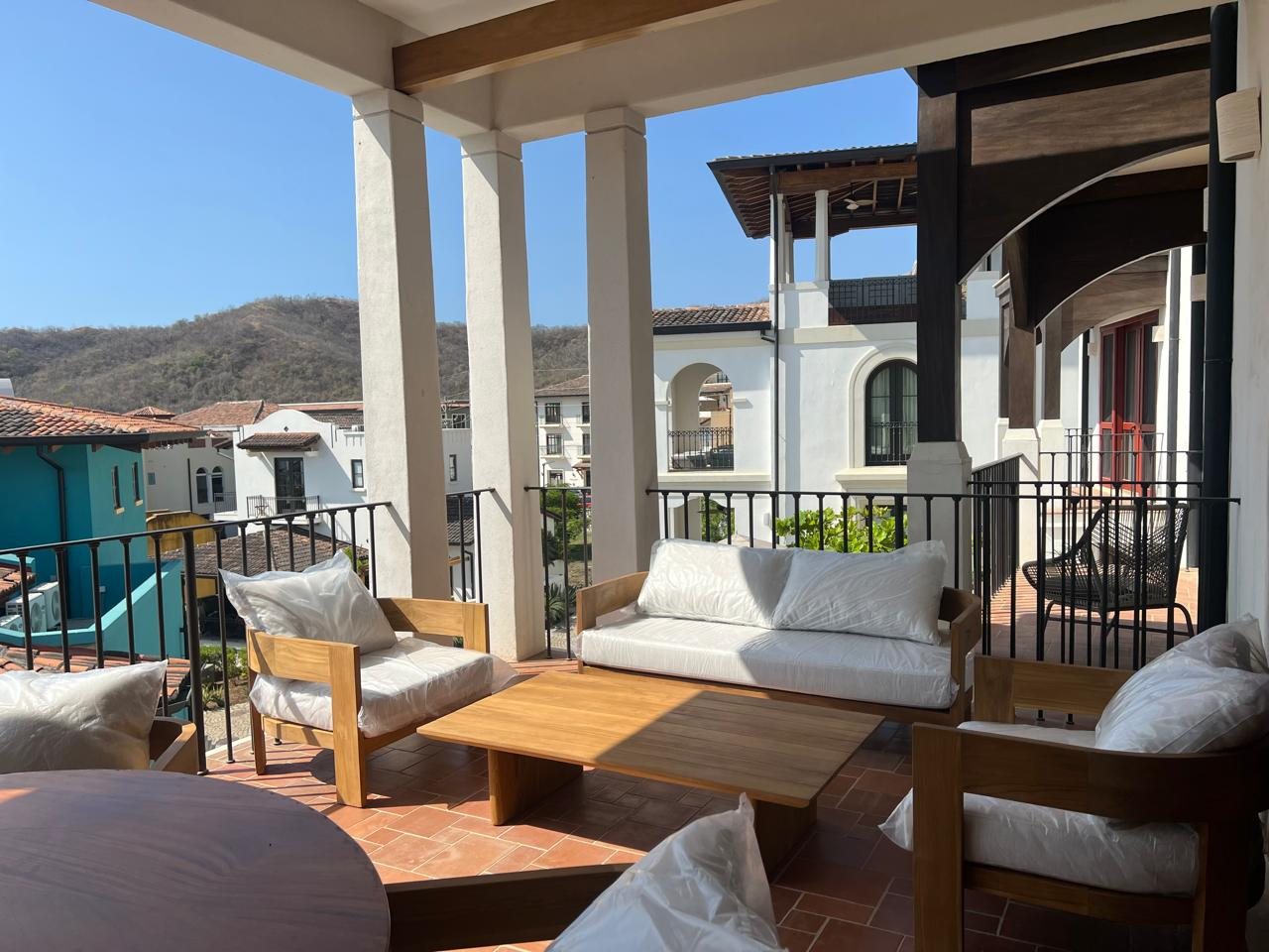 Balcony lounge with wood armchairs and a sofa