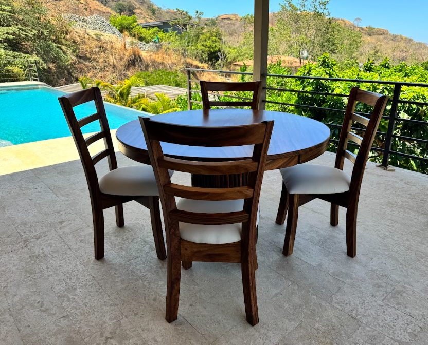 Round outdoor dining table beside the pool
