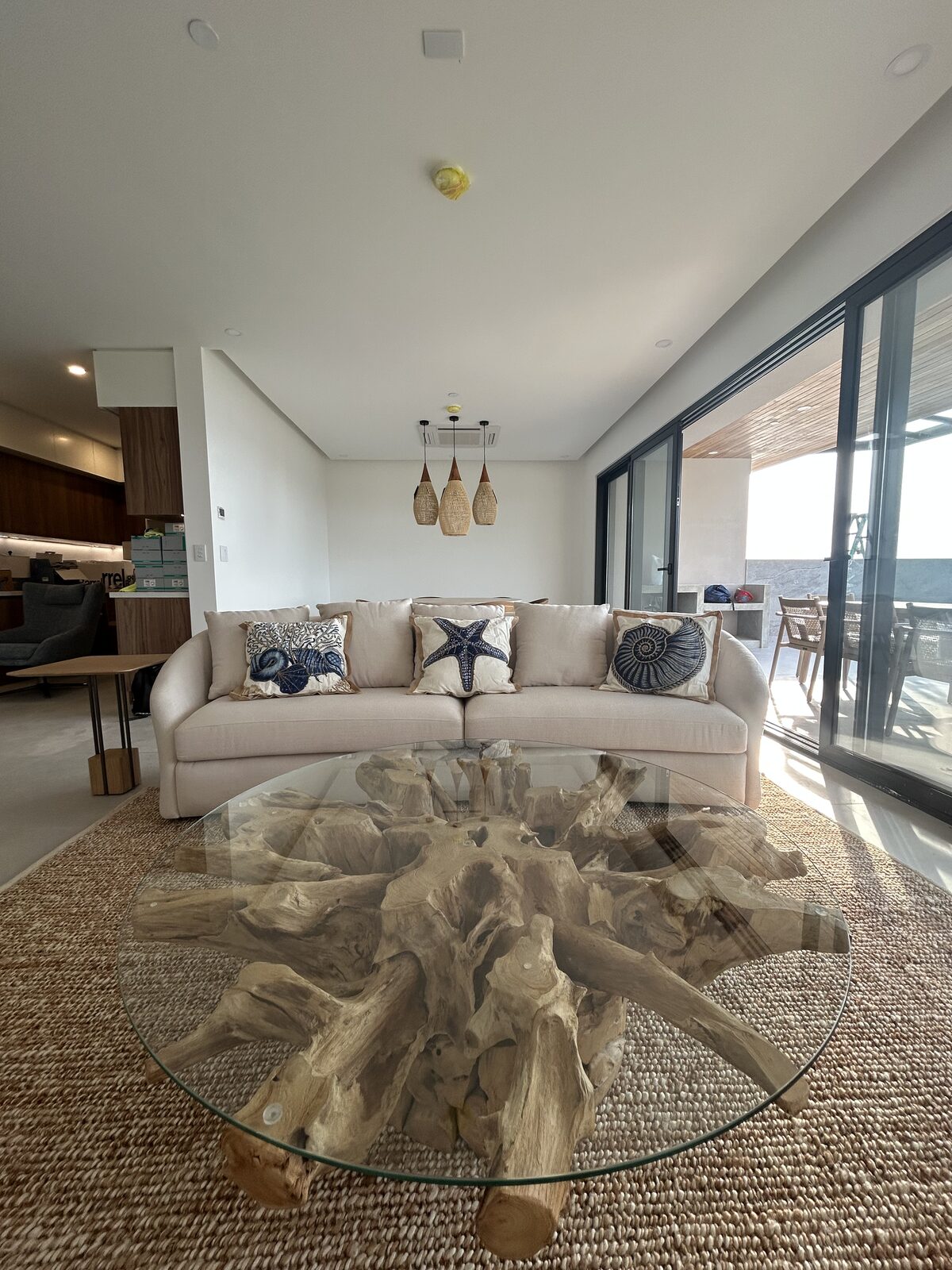 Sofa with decorative pillows and a glass-top coffee table with a natural wood base
